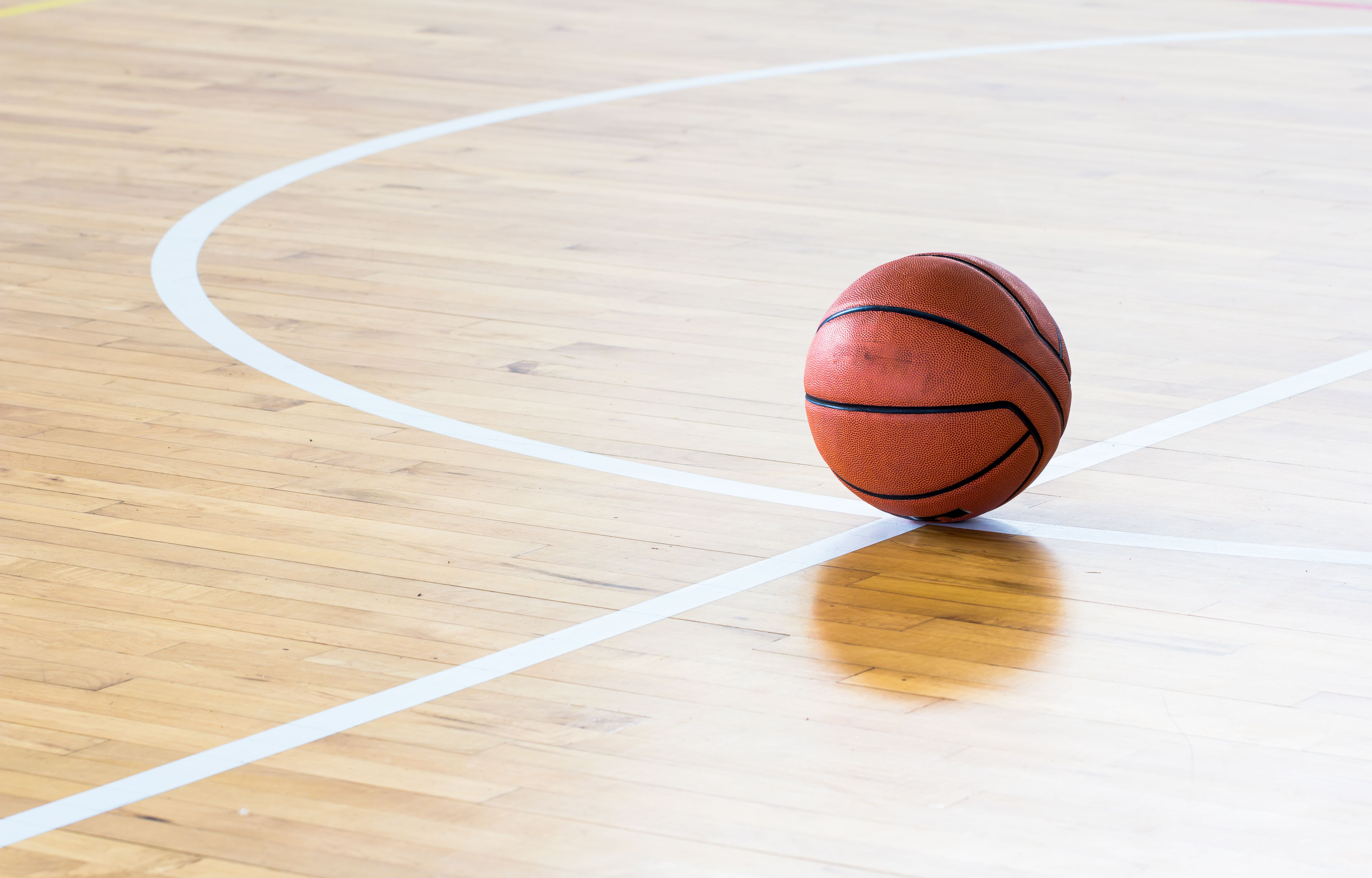 a basketball on the court of a ymca basketball gym