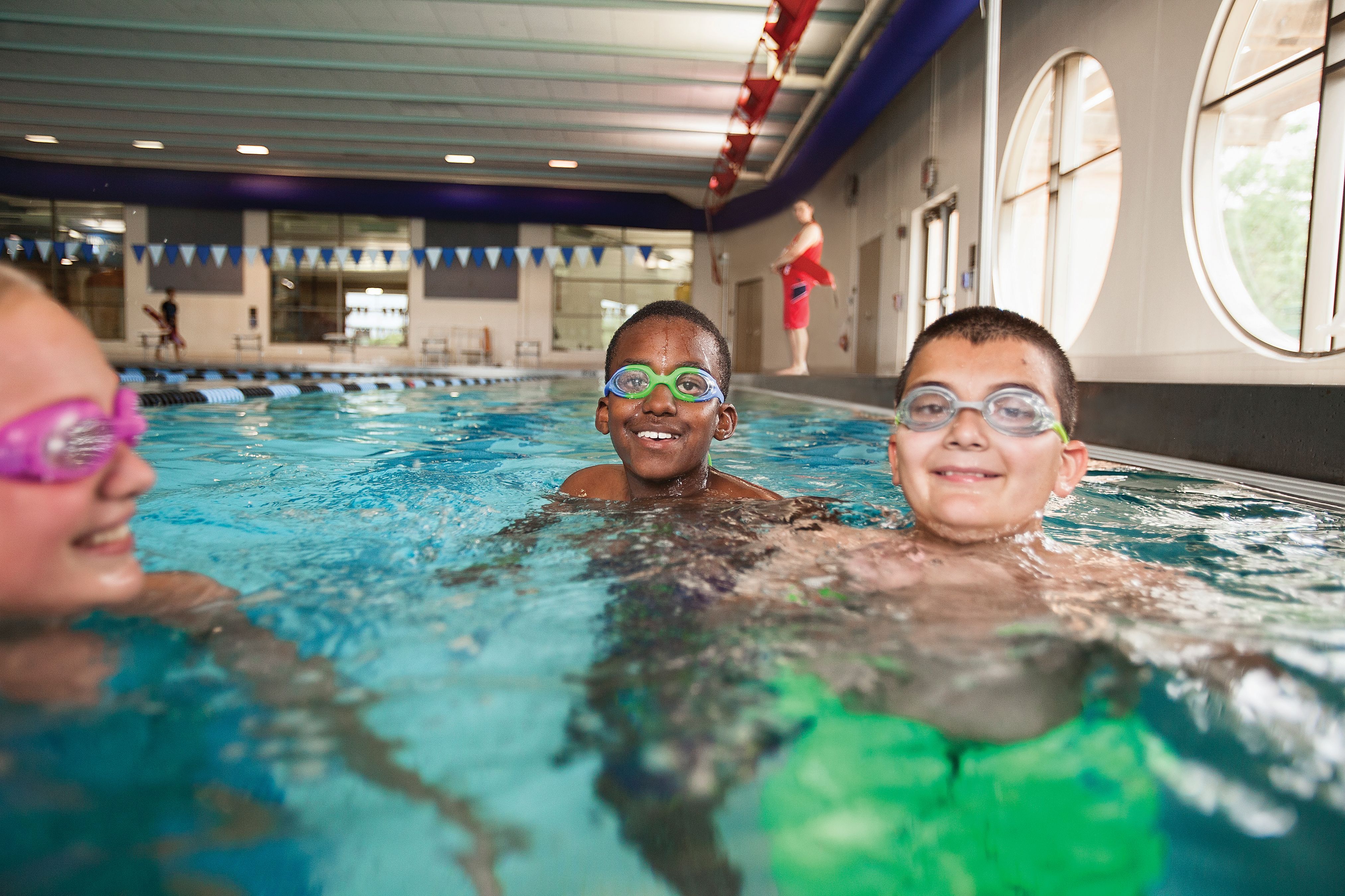 children swimming in a ymca indoor pool for a kids night out program