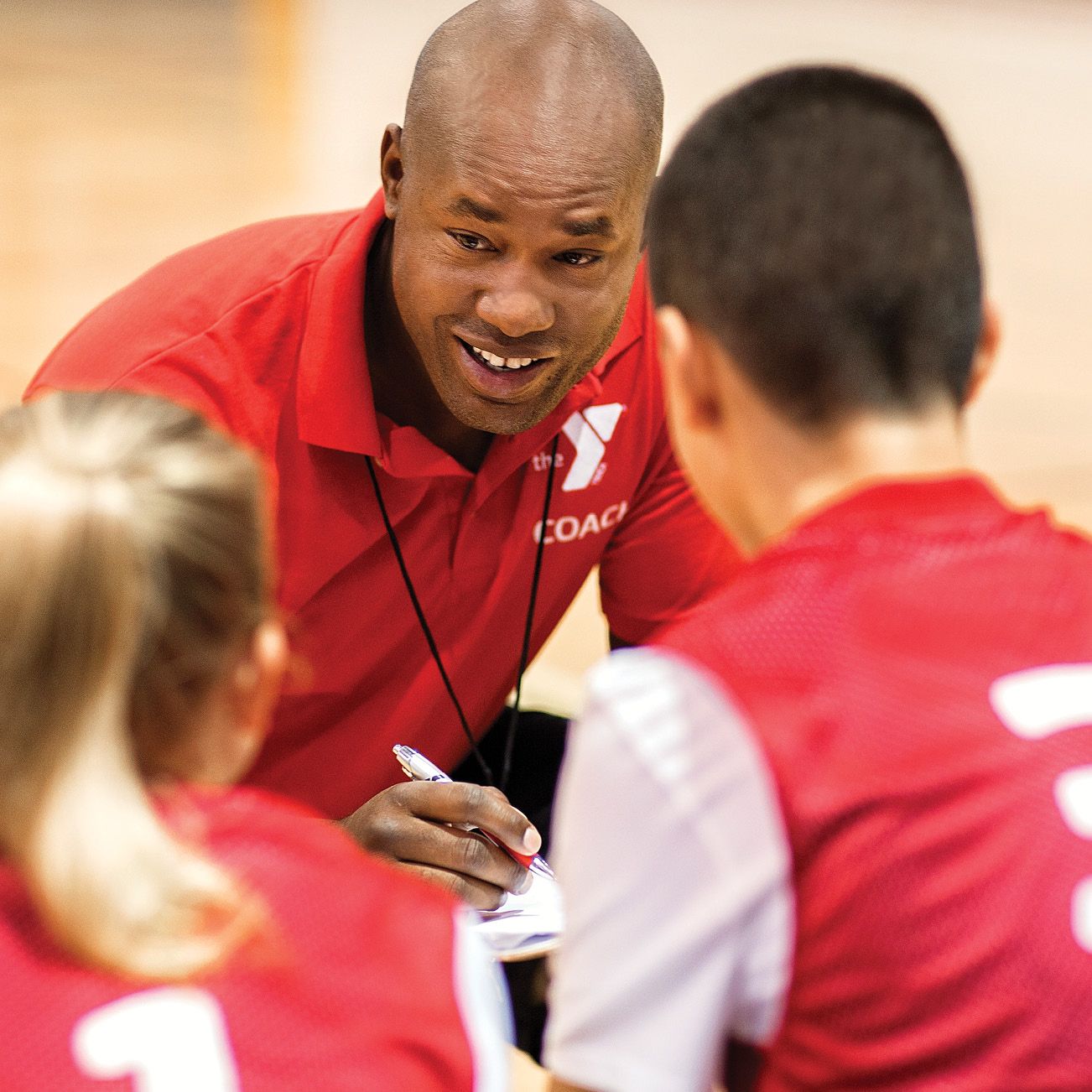 YMCA youth sports coach talking to team his team