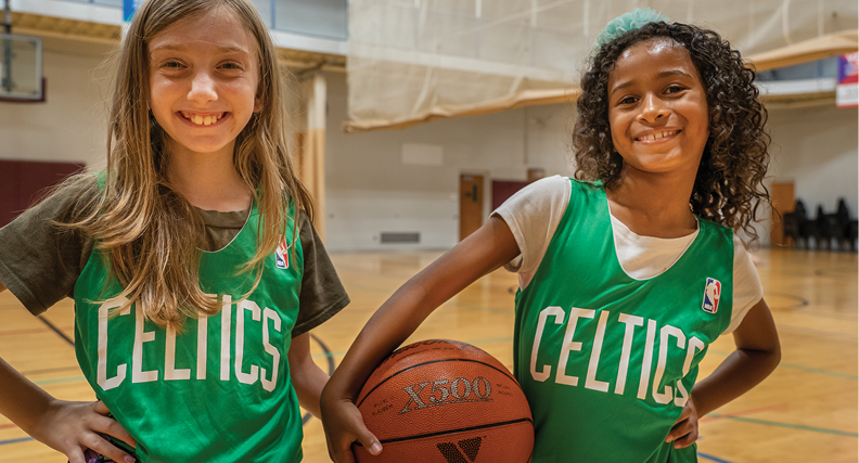 Two kids participating in a YMCA Youth Basketball League practice