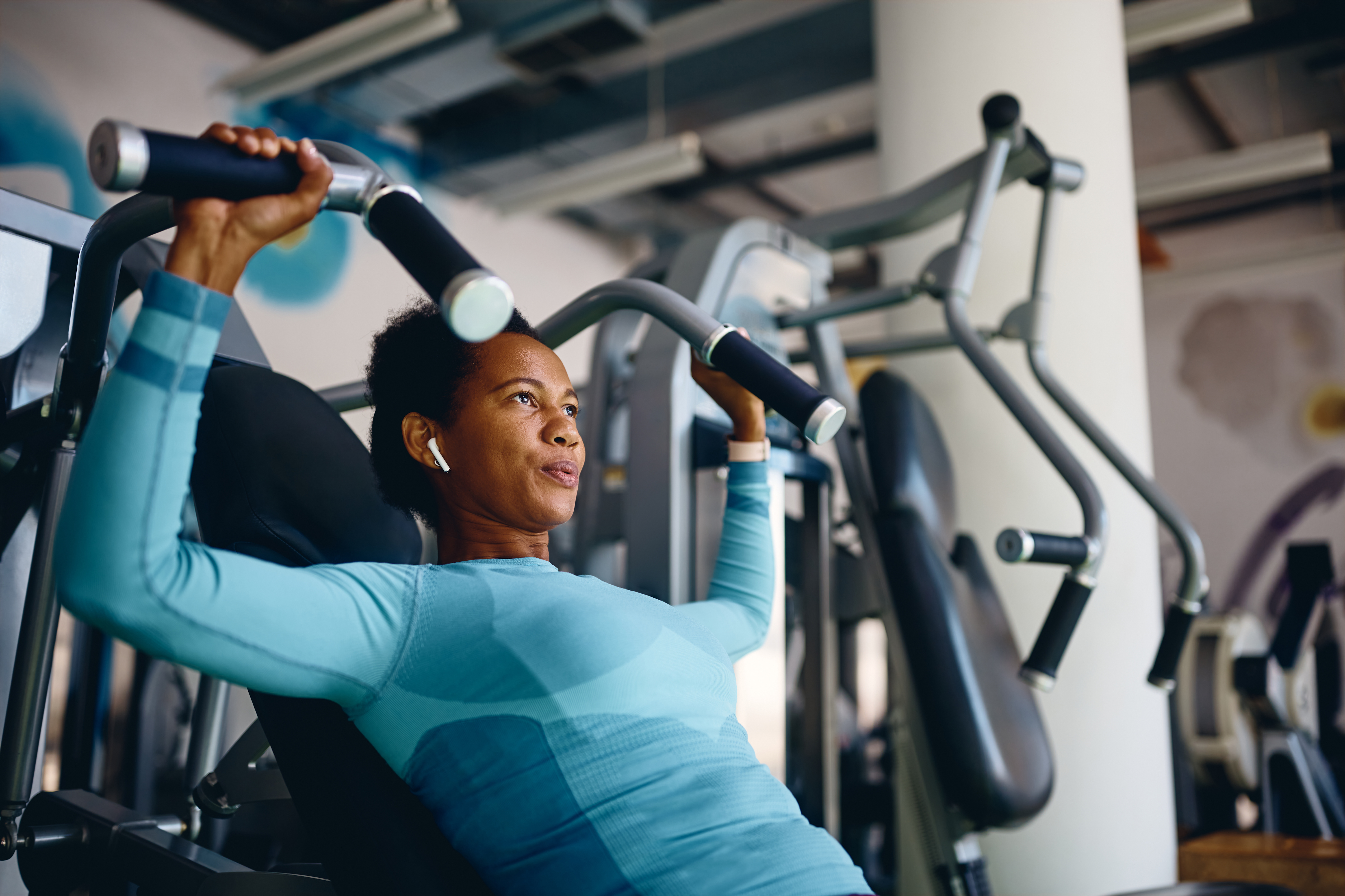 woman using strength equipment at the gym