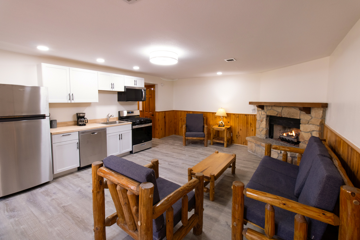 YMCA Trout Lodge Forest View Cabin Renovated Living Room Area with full kitchenette, couches, and fireplace