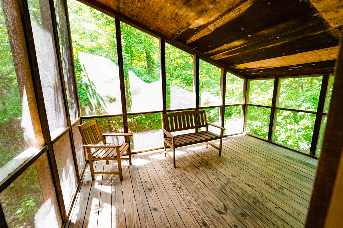 YMCA Trout Lodge Forest View Cabin Screened Porch with two seating benches and views of green treetops
