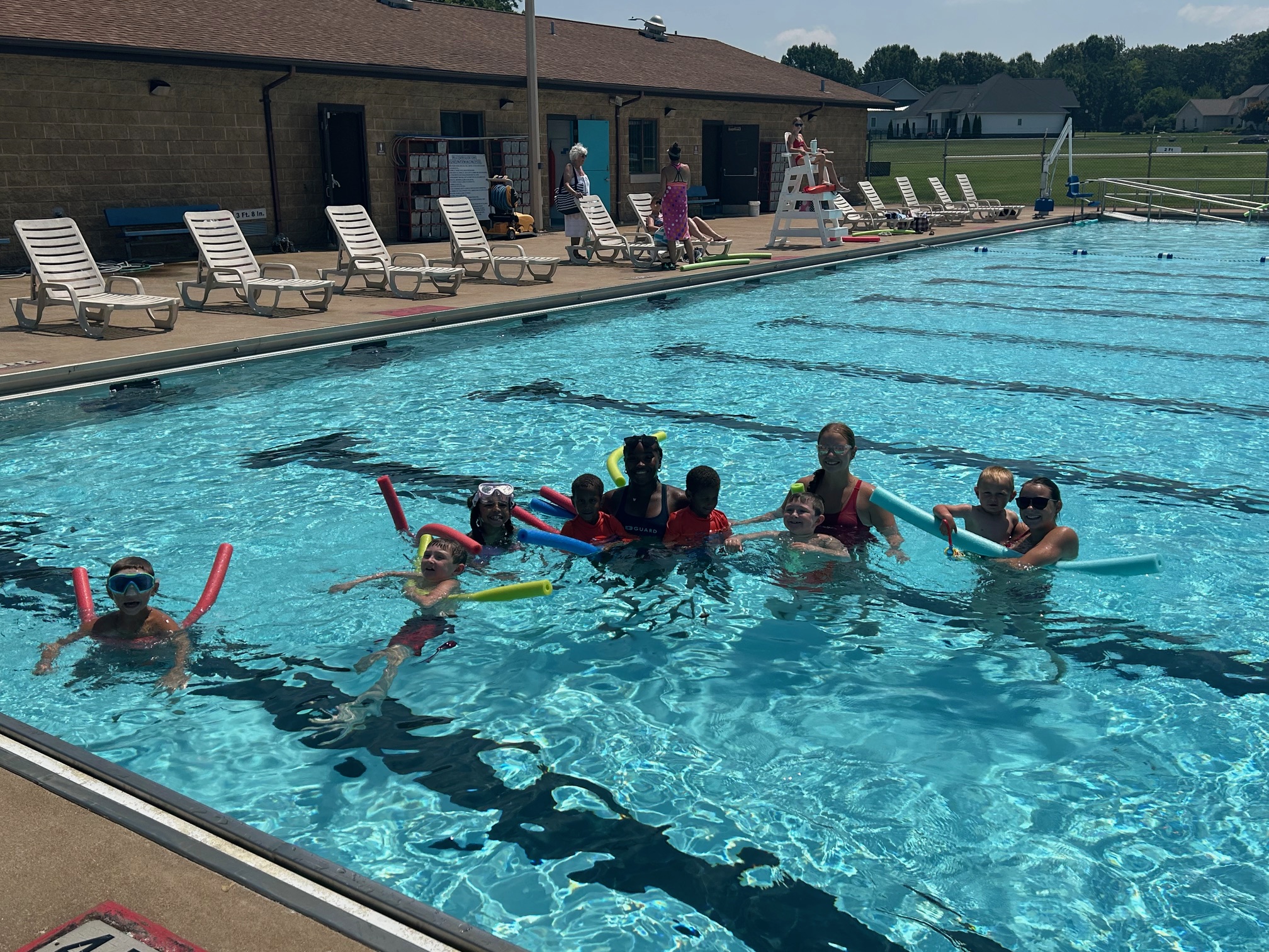 Children and instructors practicing swimming and water safety skills in the pool