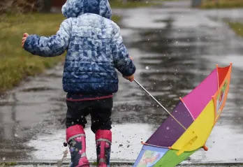child playing in the rain