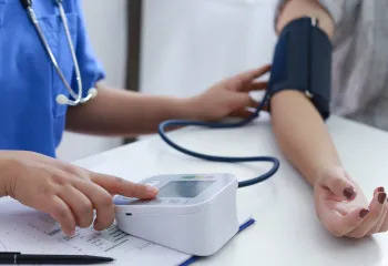 doctor taking patient's blood pressure
