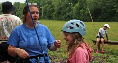 a girl in a pink sweatshirt preparing to climb a tower