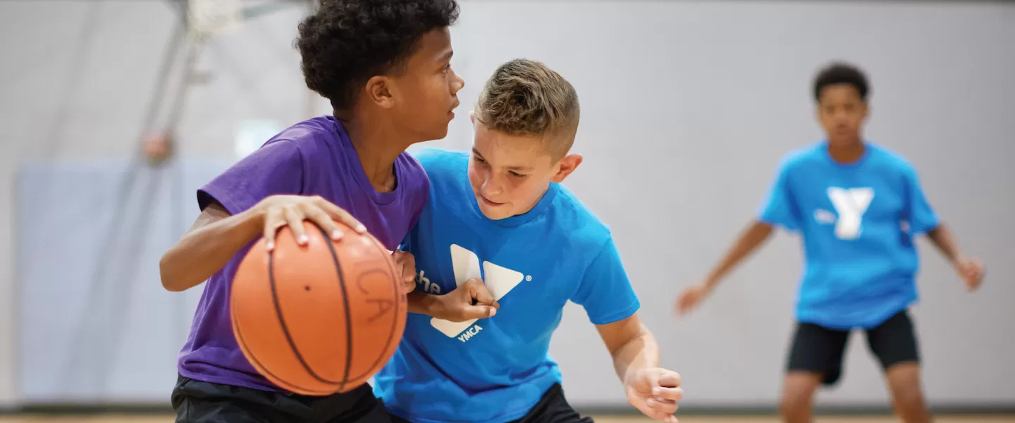 two young boys playing basketball at the ymca