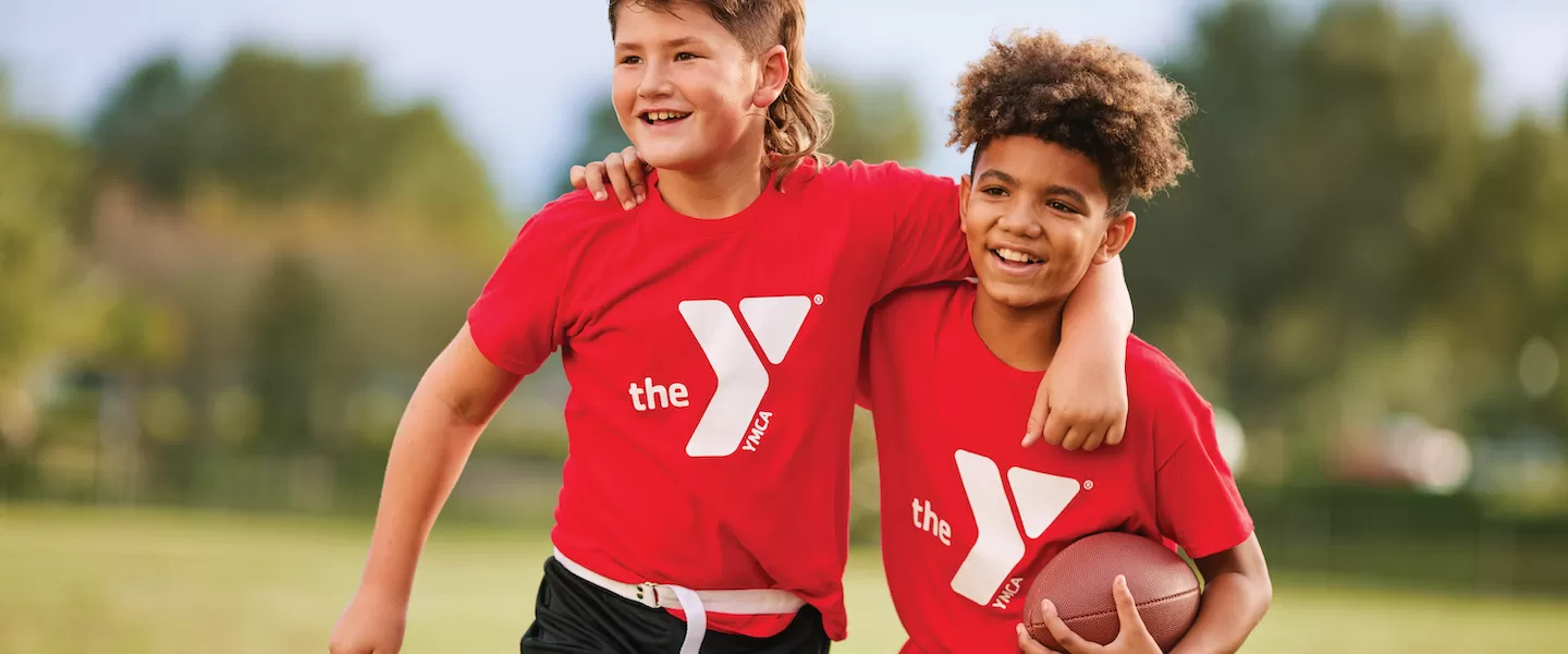 two young boys playing flag football at the ymca