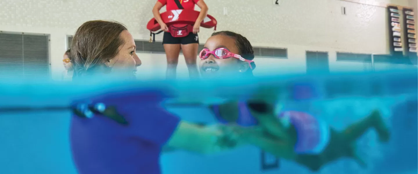 YMCA Swimming Lesson Instructor Teaching Child How to Swim