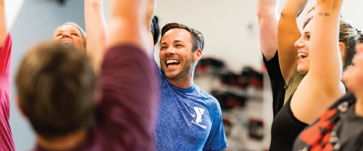 ymca group exercise instructor cheering on his group exercise class participants