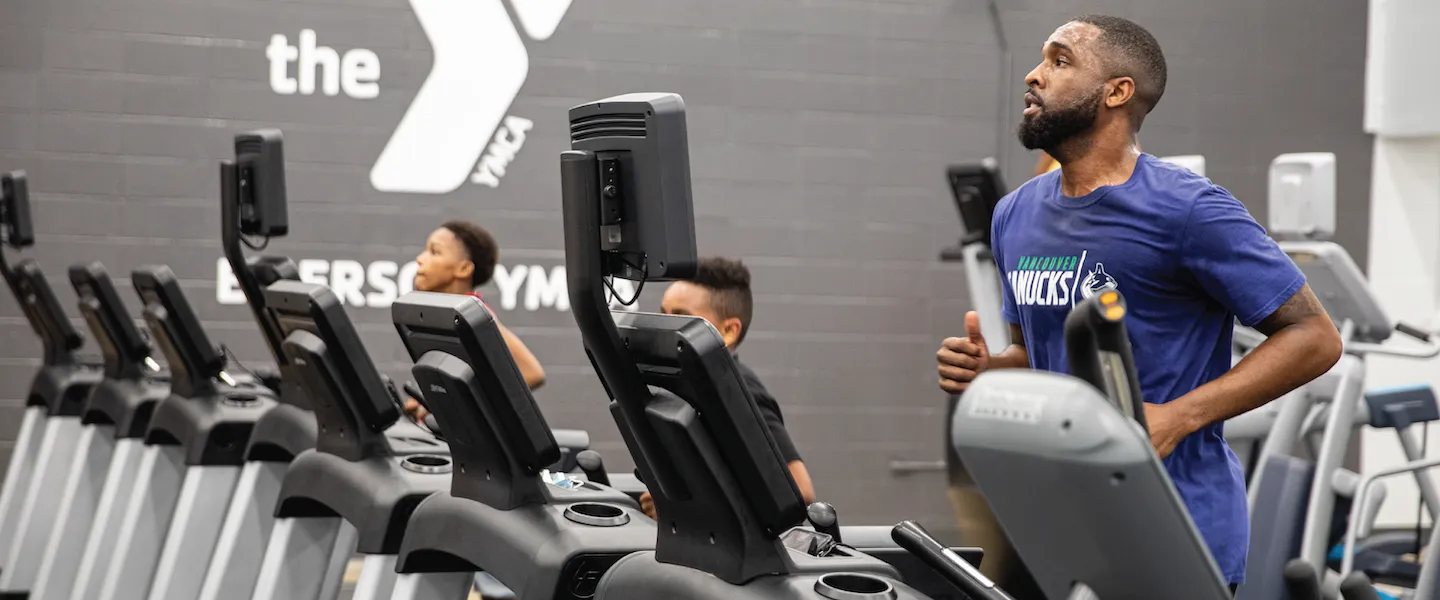man and kids running on treadmills at the ymca