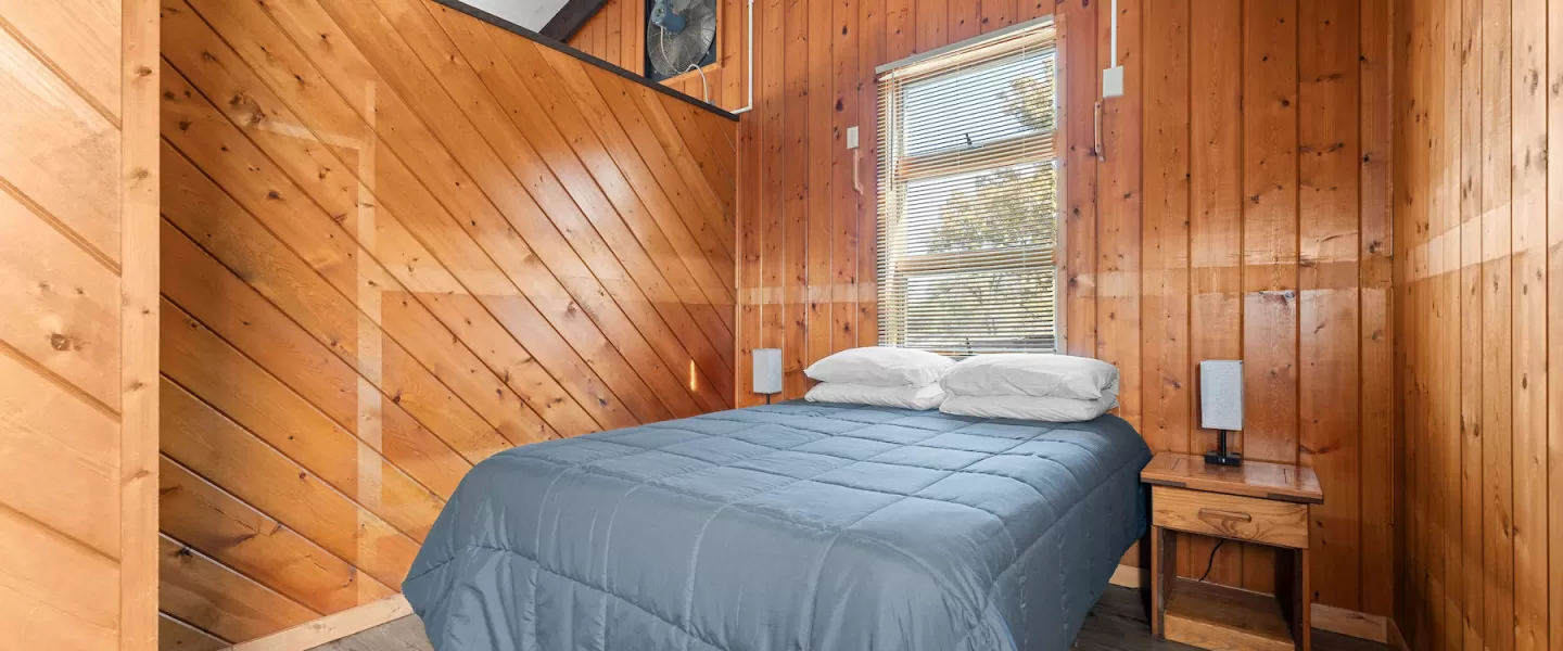 Bedroom with queen-size bed and side table bedroom cabin furnishings at Bluff View Cabin