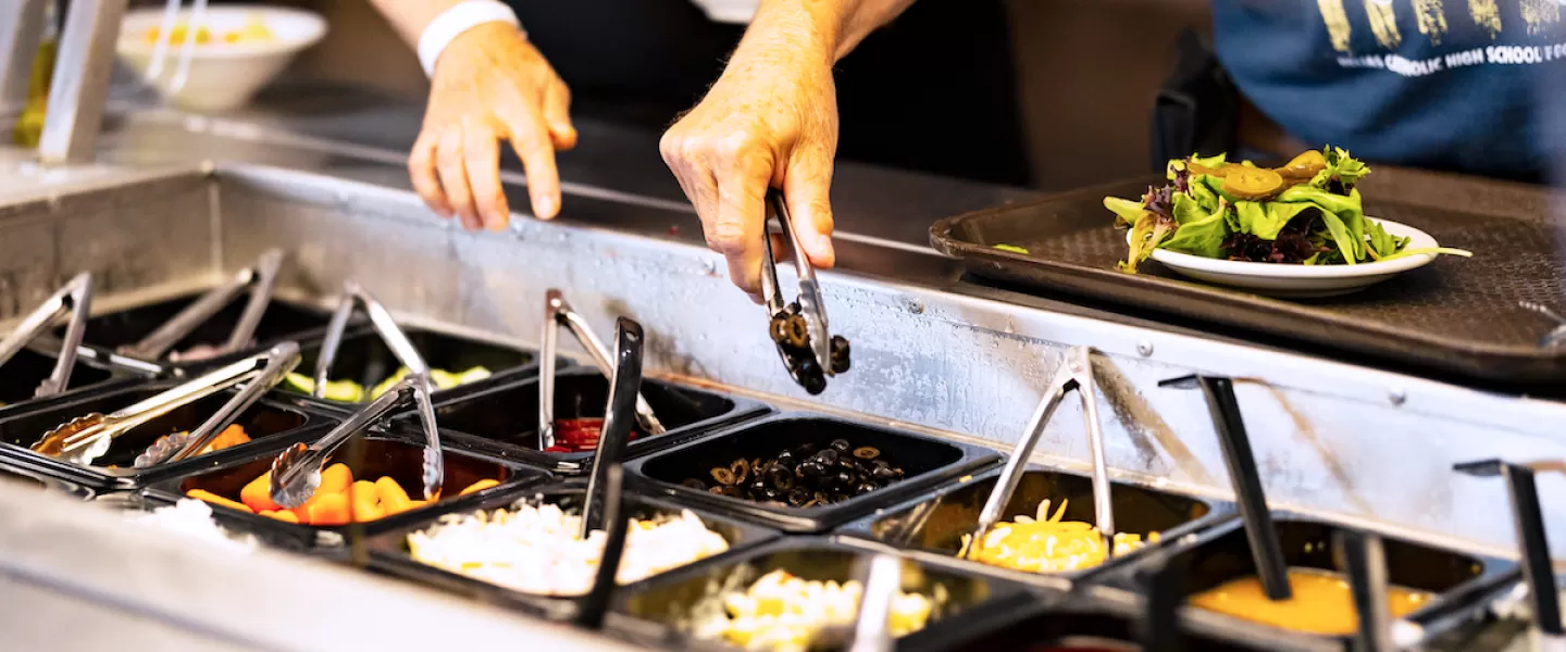 Self-serve salad bar with fresh vegetables and assorted toppings at YMCA Trout Lodge Dining Hall