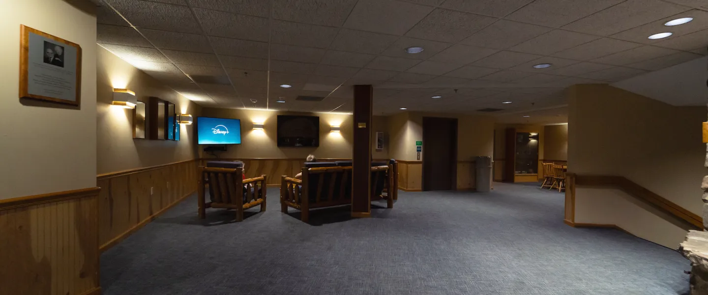 Trout Lodge hallway lounge with couches, TV, and game table near guest rooms