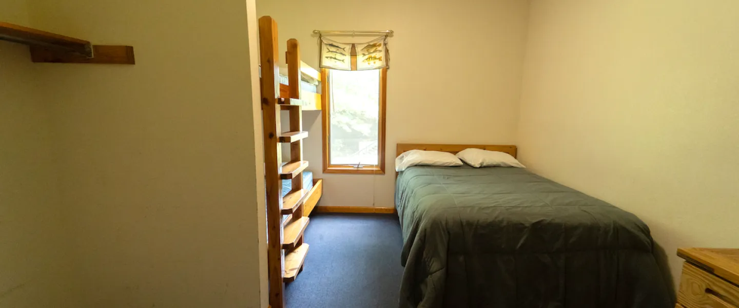 Tidy bedroom in a Forest View Cabin with comfortable beds and simple, rustic furnishings for a restful night's sleep in the woods.