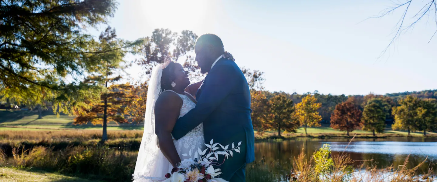 Bride and groom sharing a romantic moment on the shore of the lake at their YMCA Trout Lodge wedding.