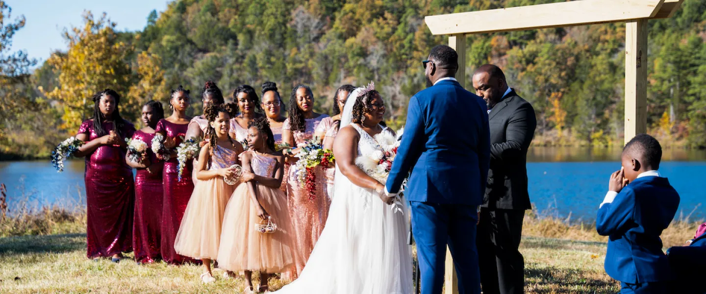 A close-up view of a couple exchanging vows during their wedding ceremony at YMCA Trout Lodge.