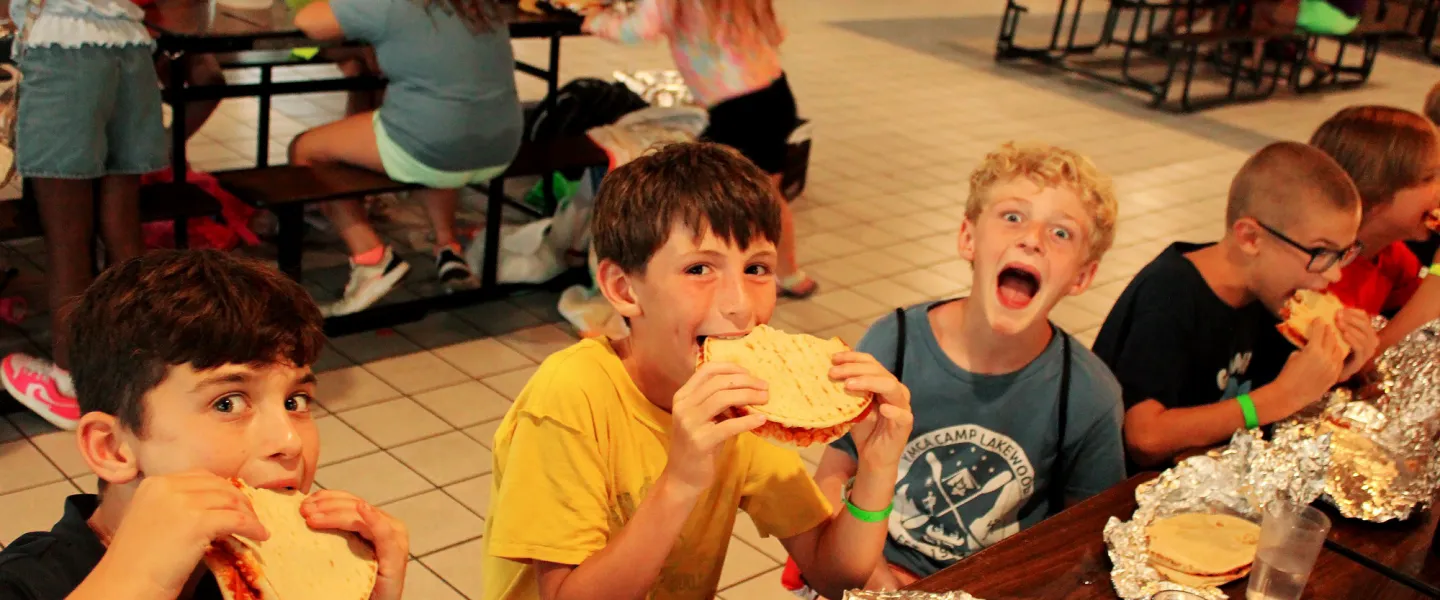 Campers in the YMCA Camp Lakewood Dining Hall eating food for dinner