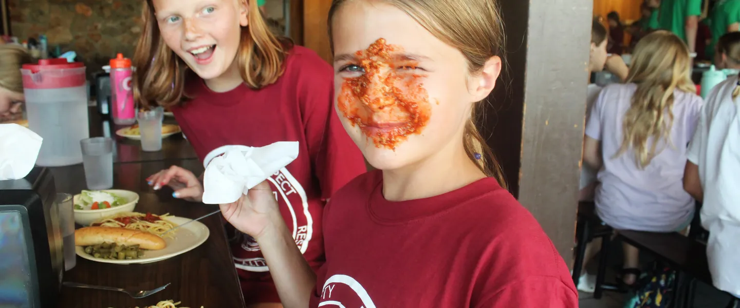 YMCA Camp Lakewood Dining Hall and Food Service Spaghetti Night camper with sauce on their face