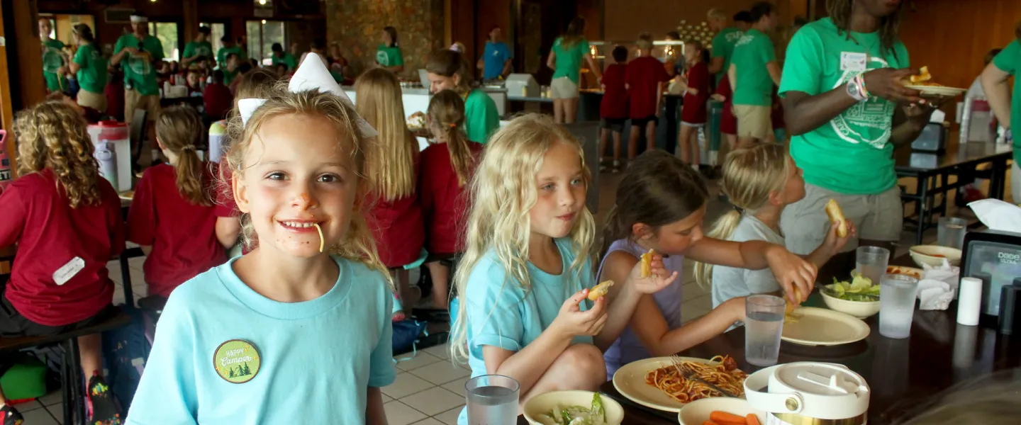 A happy camper laughing while enjoying the famous 'utensils optional' Sunday Night Spaghetti dinner.