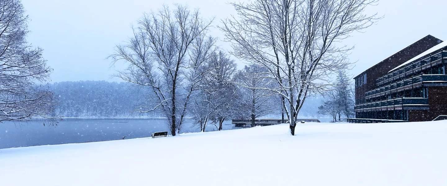 View of the cozy YMCA Trout Lodge and cabins nestled on the banks of the frozen Sunnen Lake.