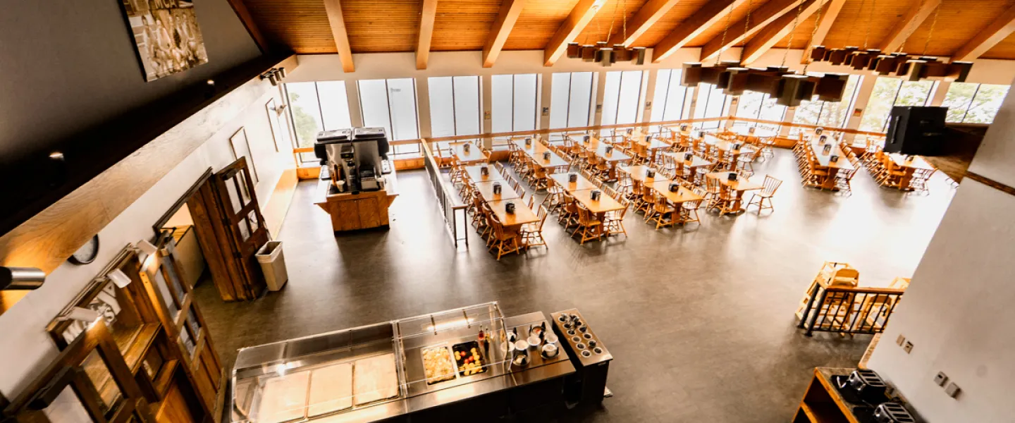 YMCA Trout Lodge Dining Hall interior aerial shot of dining tables, buffet line, and windows with Sunnen Lake views.