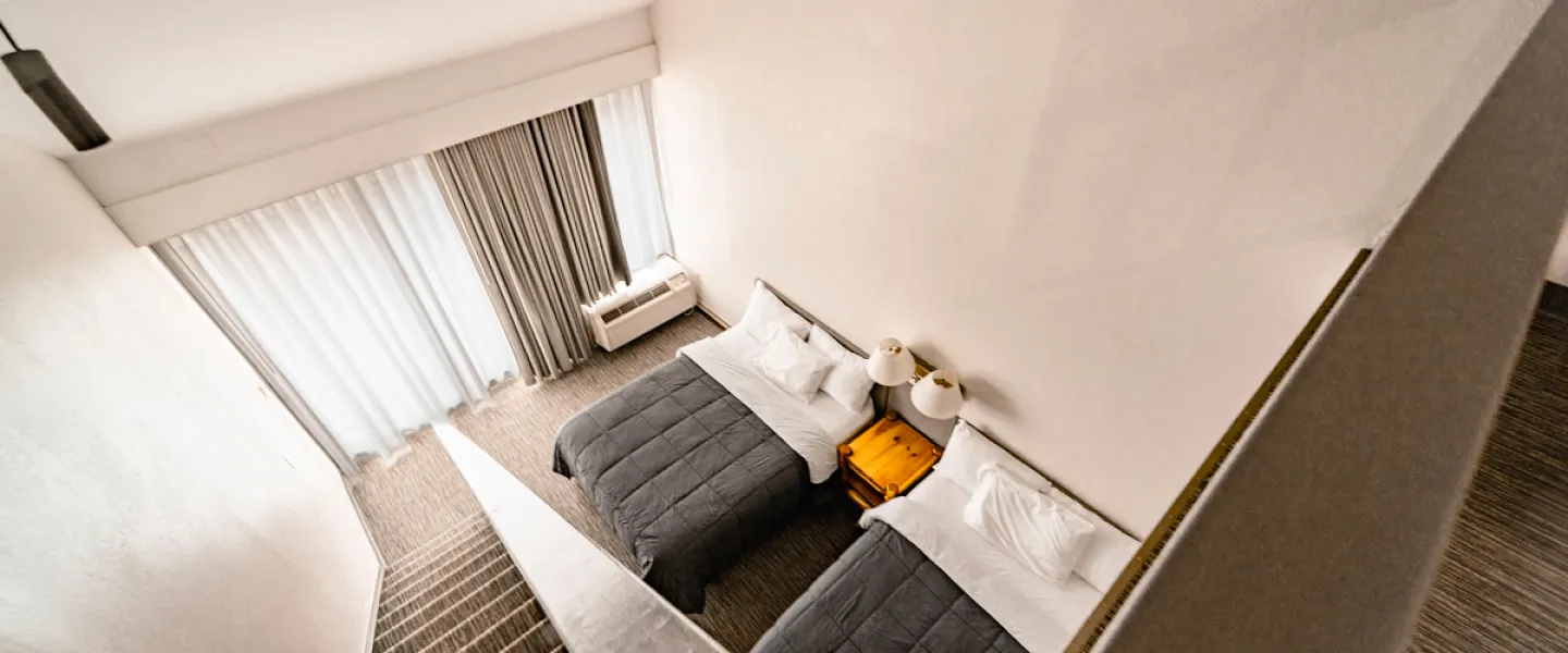 A shot of the two queen beds in the lower level of the Trout Lodge Loft Guest Room taken from the loft view