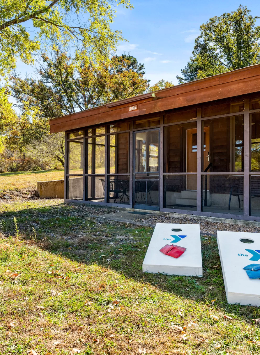 YMCA Trout Lodge in Potosi, MO Bluff View Cabin Exterior with Screened Porch, patio furniture, and grill