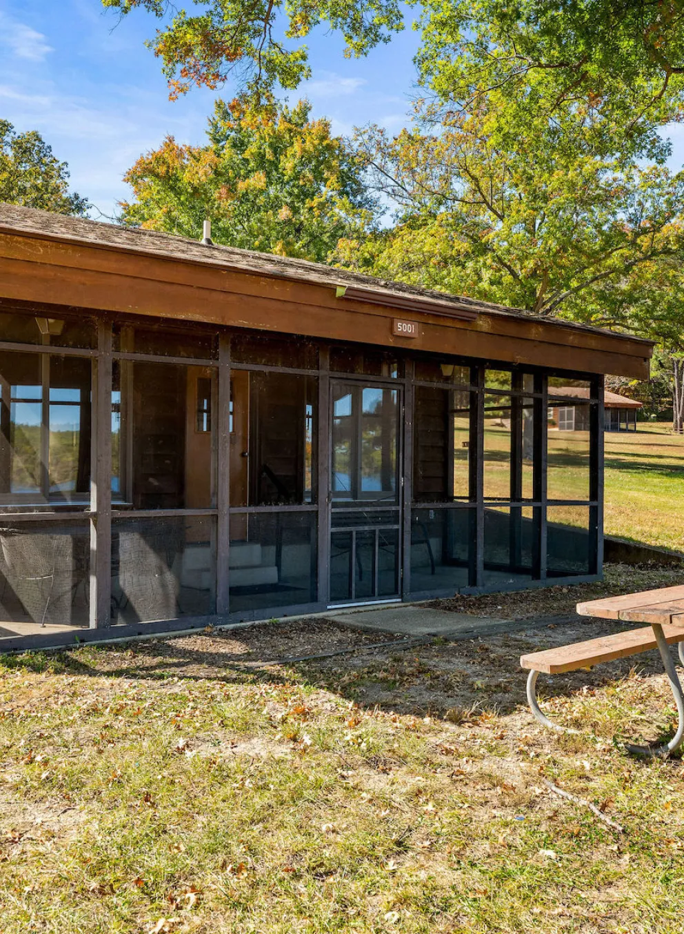 Exterior of Bluff View Cabin with screened-in porch, picnic table, and charcoal grill near Sunnen Lake