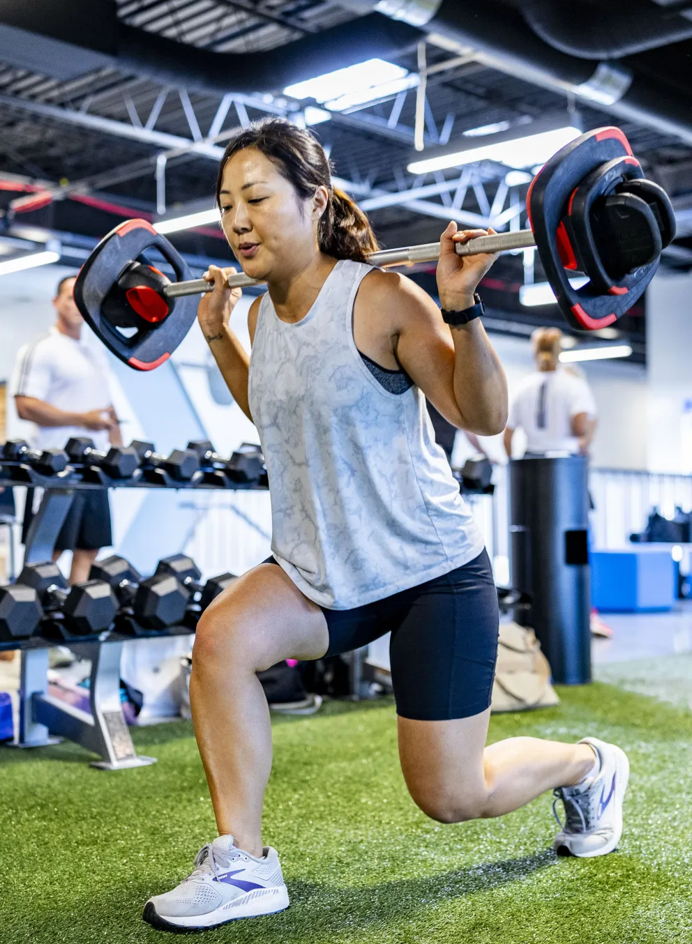 A woman lifting LesMills weights in a small group exercise class
