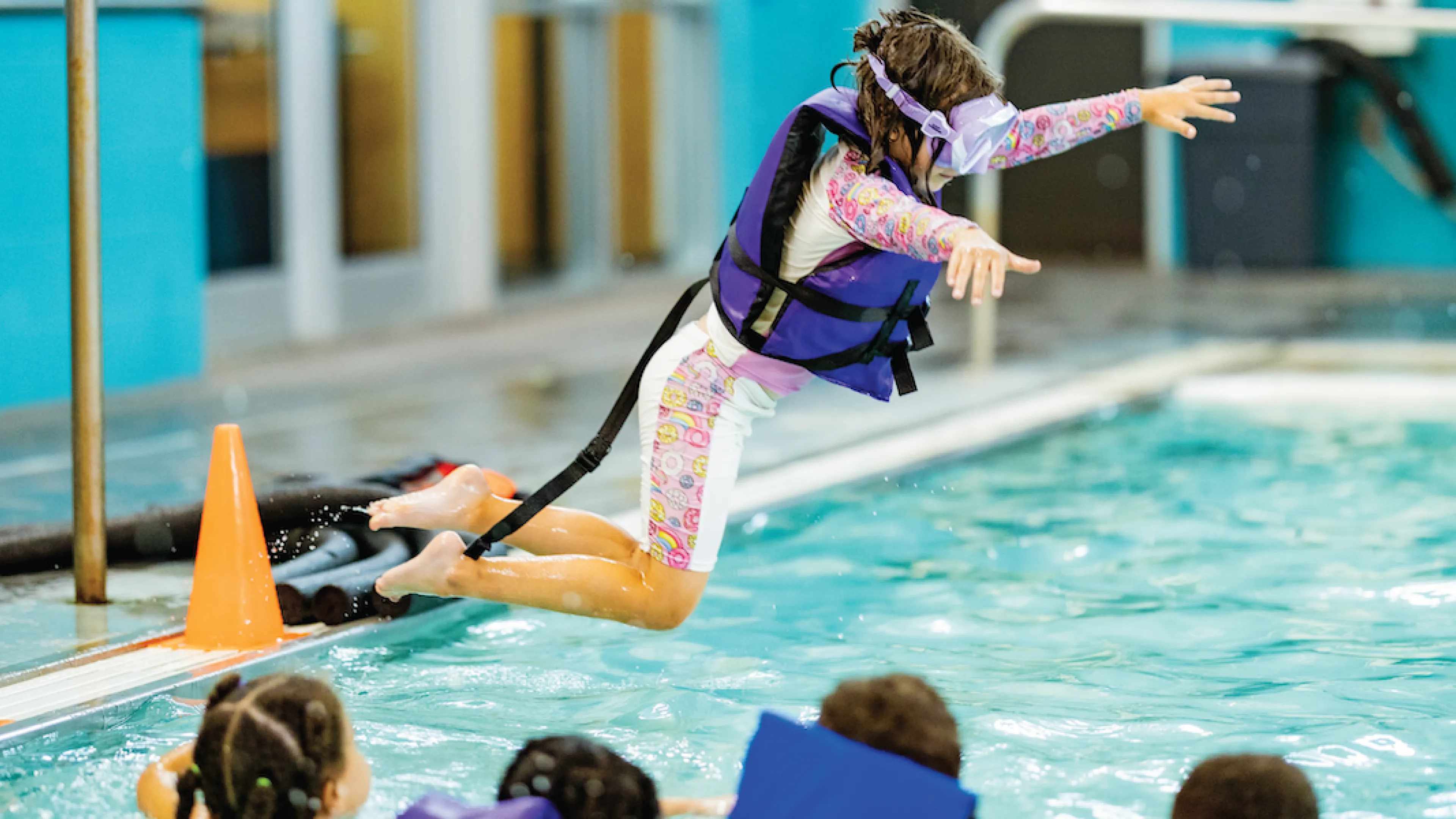 little girl jumping into pool at ymca swim lessons
