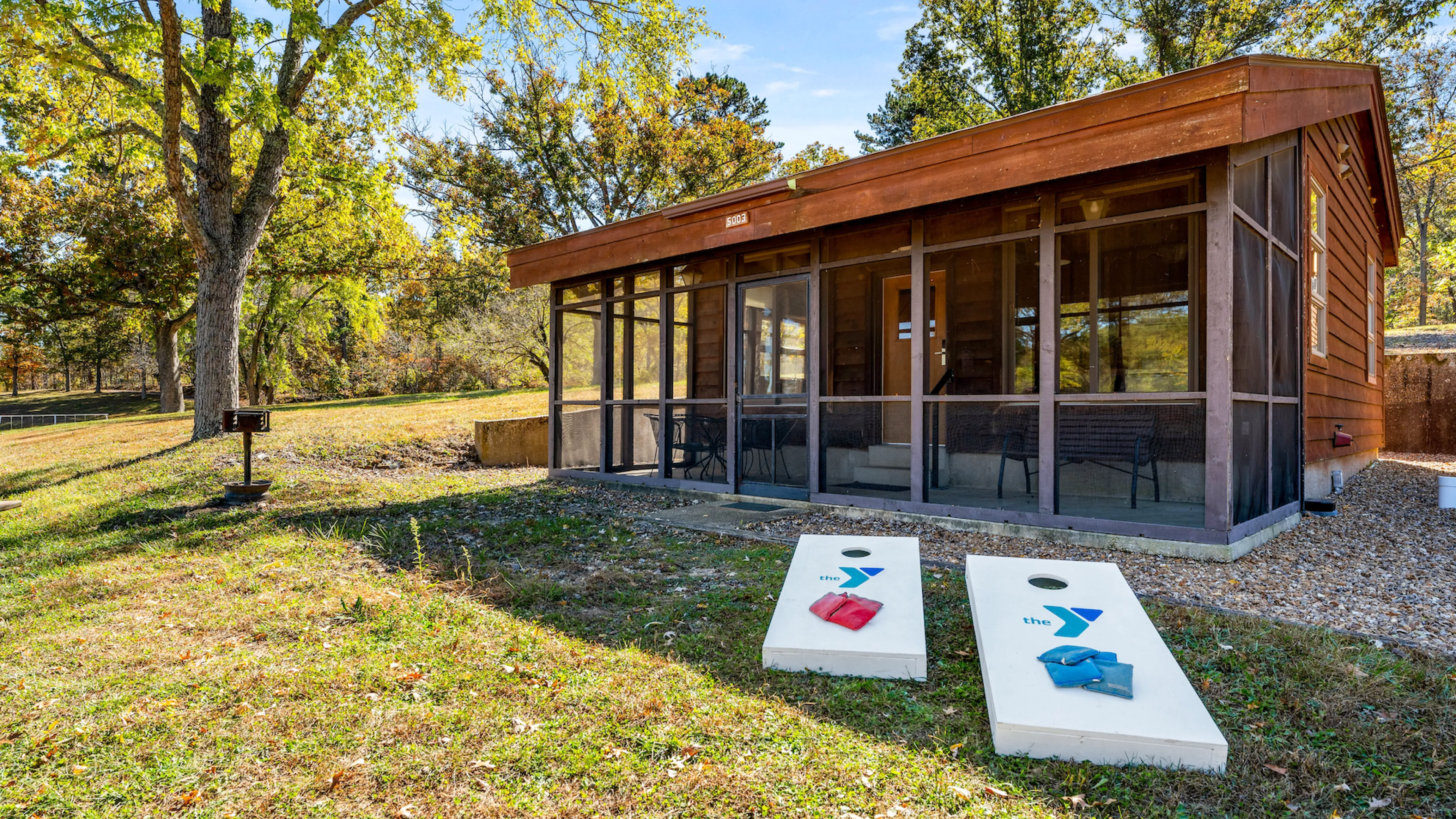 YMCA Trout Lodge in Potosi, MO Bluff View Cabin Exterior with Screened Porch, patio furniture, and grill