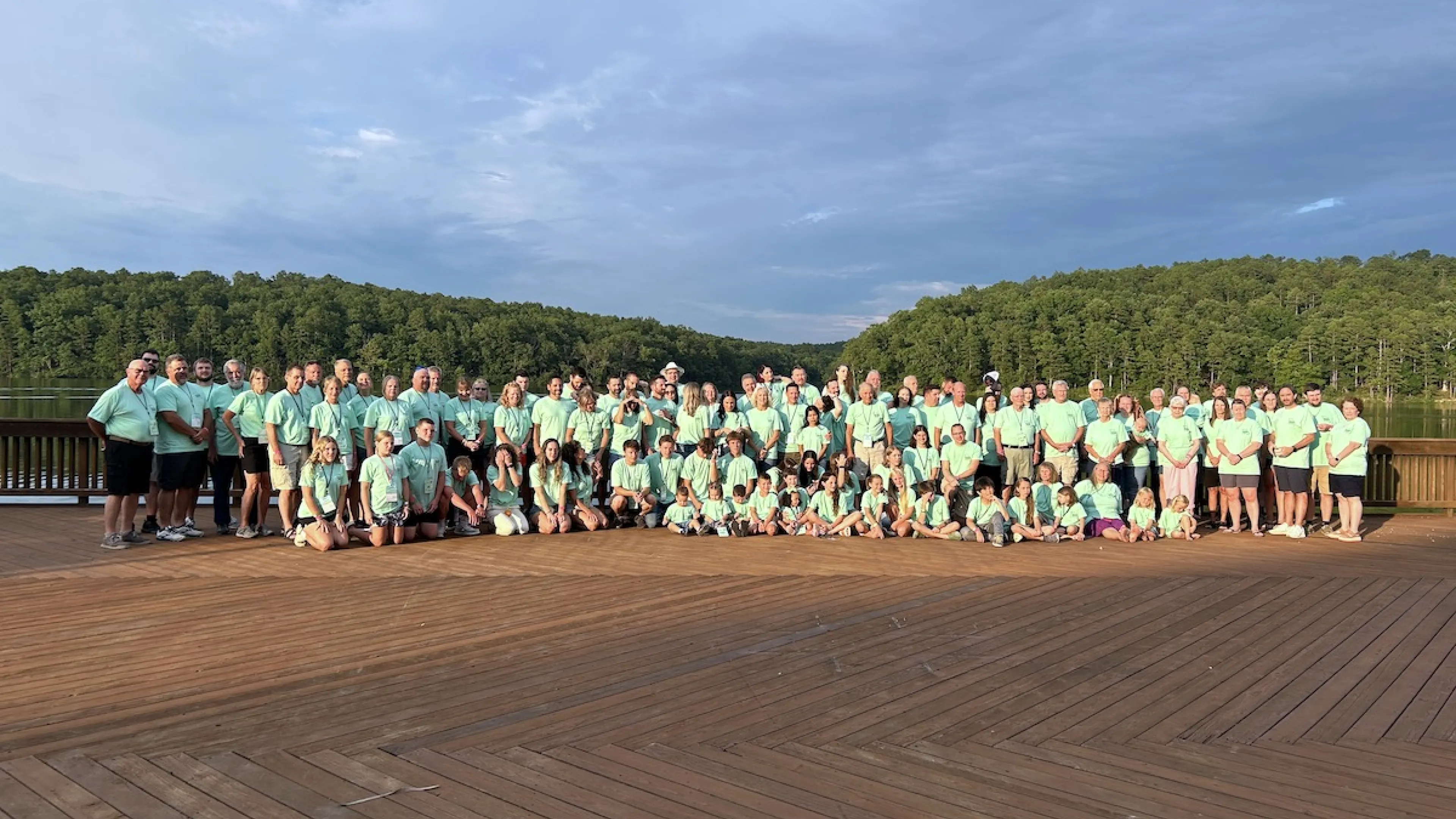 Family reunion posing for a group photo on the Trout Lodge deck in front of Sunnen Lake