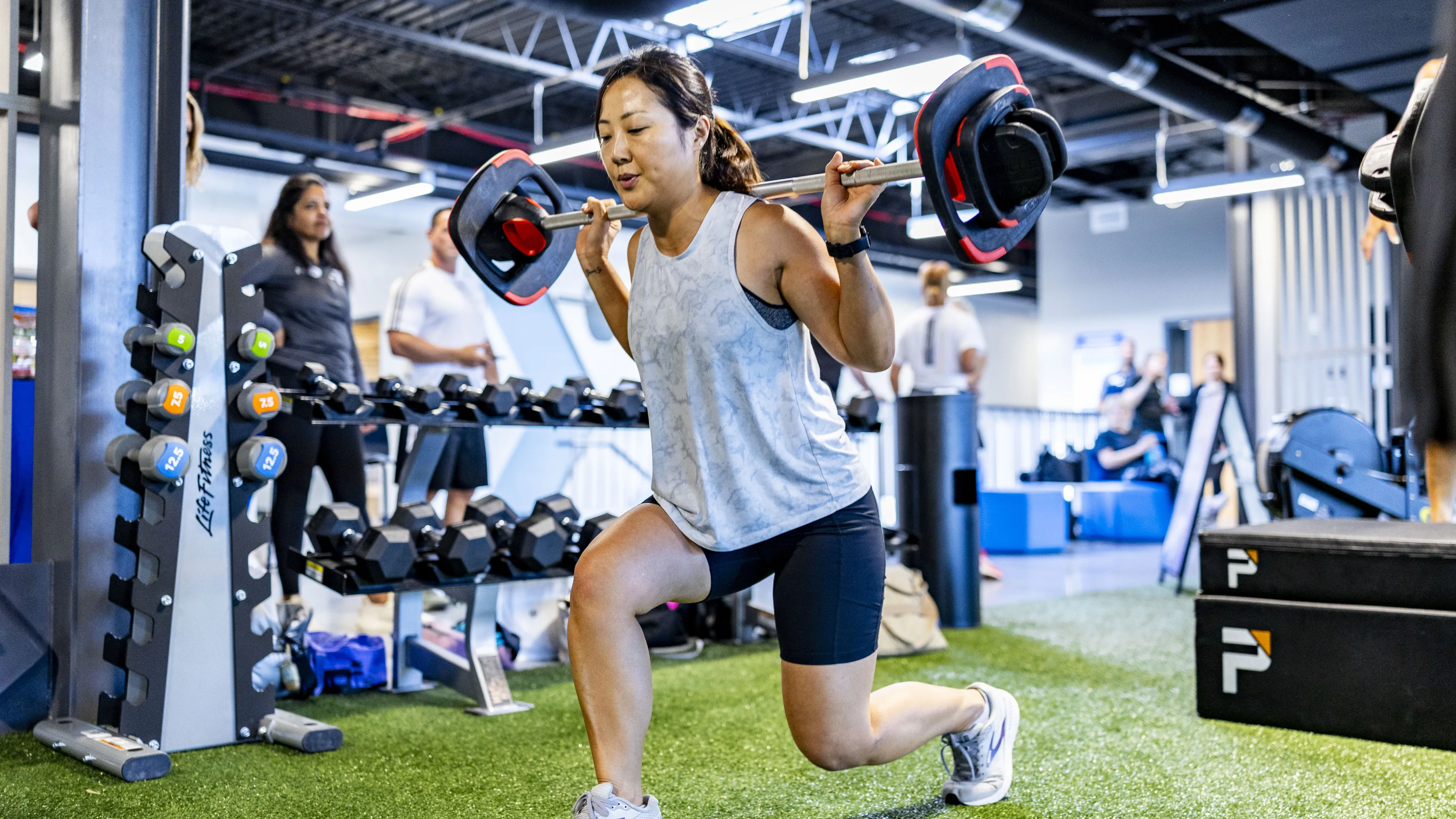 A woman lifting LesMills weights in a small group exercise class
