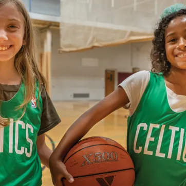 Two kids participating in a YMCA Youth Basketball League practice