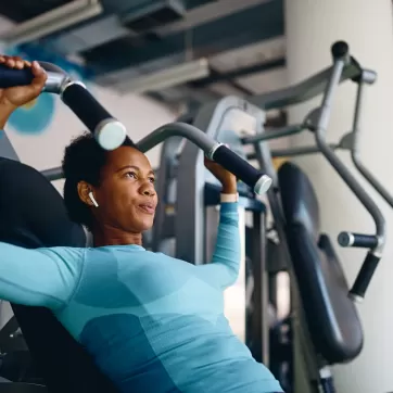 woman using strength equipment at the gym