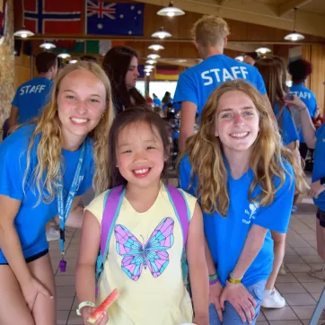 ymca camp lakewood camper with two counselors smiling