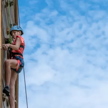 child doing climbing wall at ymca trout lodge and camp lakewood