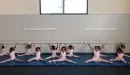 Thumbnail: Eleven young female African American dancers pose in the splits during a ballet class at the local YMCA.
