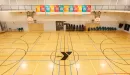 Thumbnail: Gymnasium with lines for basketball, pickleball, and volleyball. Overhead track around perimeter of gym.