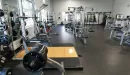 Thumbnail: Large room with weight lifting racks and platforms along wall. Weight machines in middle of floor.