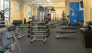 Thumbnail: Free weight area with benches, bars, dumbbells, and a faux-grass core and functional training area.