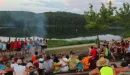 Thumbnail: group seated at campfire overlooking the lake