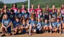 Thumbnail: Counselors and campers in camp shirts posing by the lake