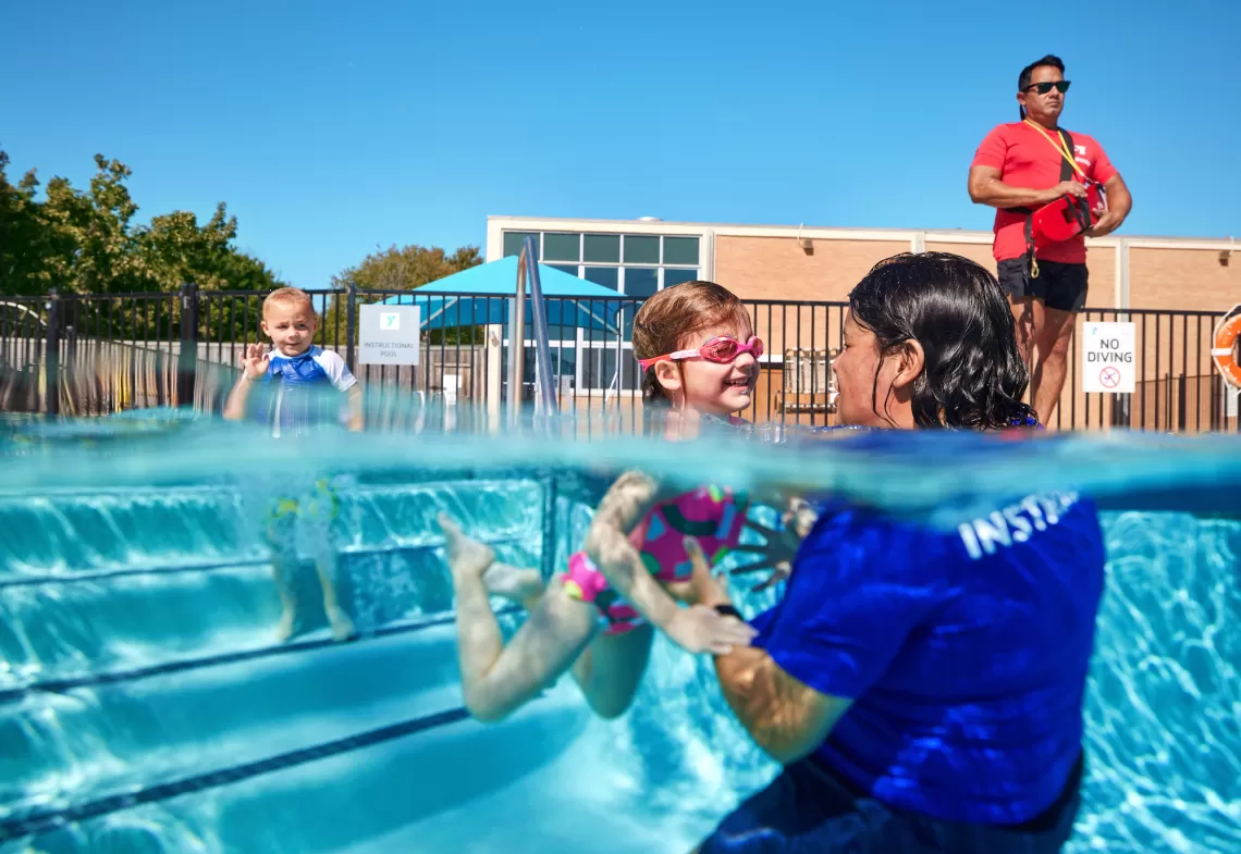 YMCA Preschool Swimming Lesson taking place with a Y Swim Instructor and Child in a YMCA Outdoor Swimming Pool