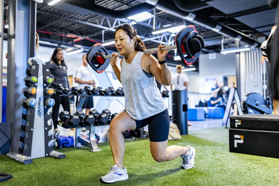 A woman lifting LesMills weights in a small group exercise class