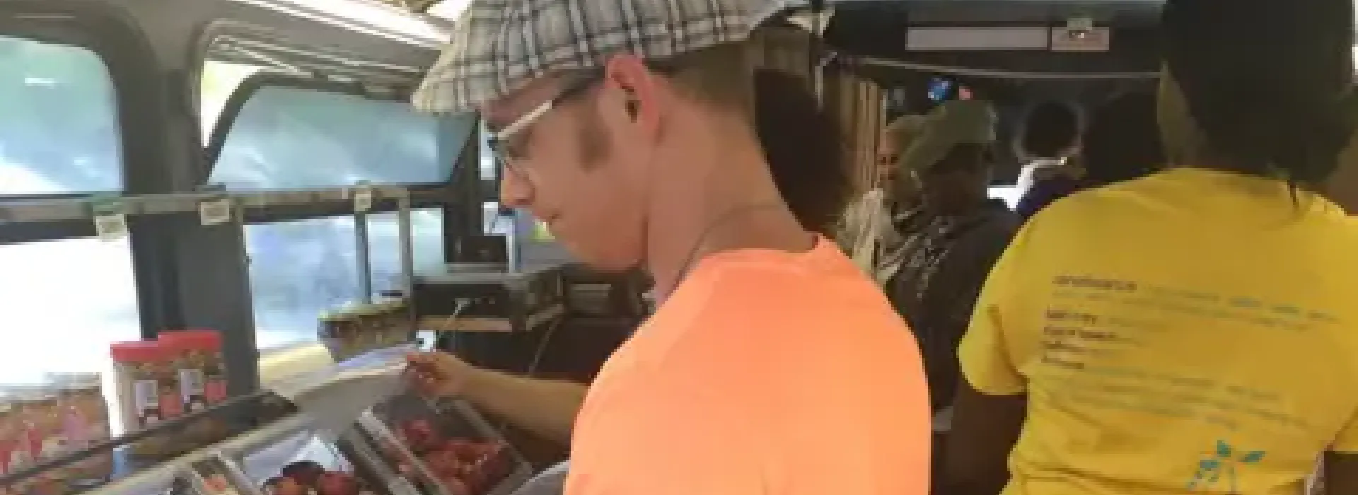 An image of Caucasian and African American male and female volunteers on the YMCA's food bus.
