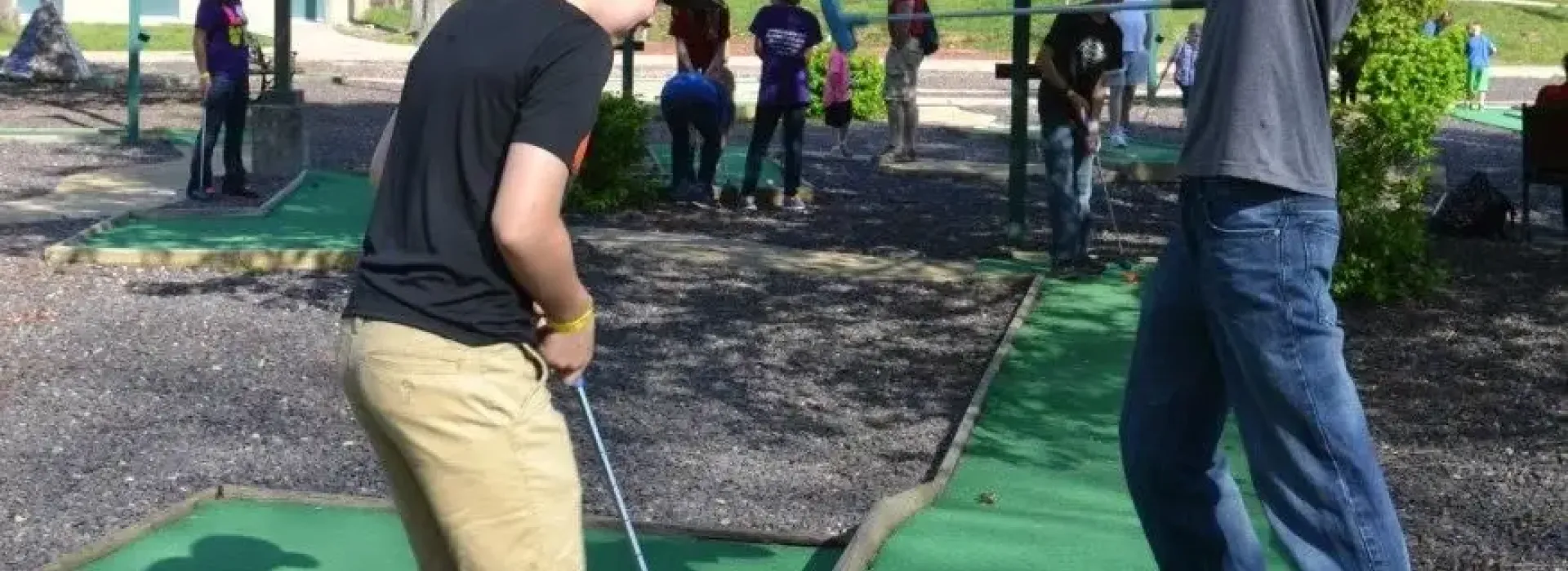 Two boys playing mini golf