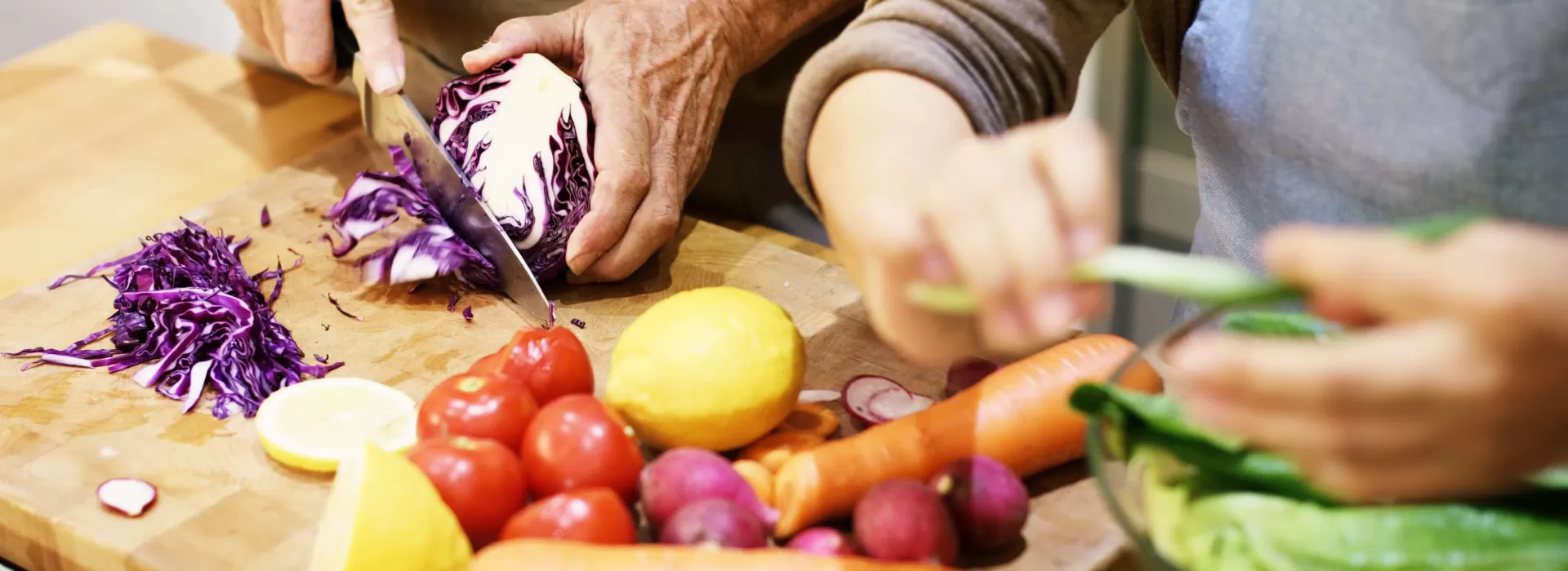 people cutting vegetables on a cutting board